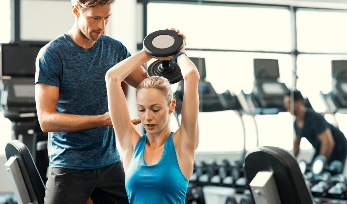 Personal Trainer working with client at gym