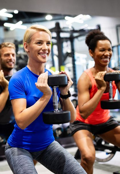 Team of clients working out at gym with weights - Strength & Conditioning