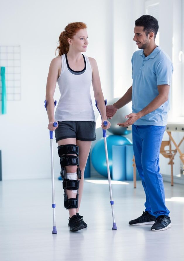 Woman client on crutches getting helped by Personal Trainer Upstream Athletics