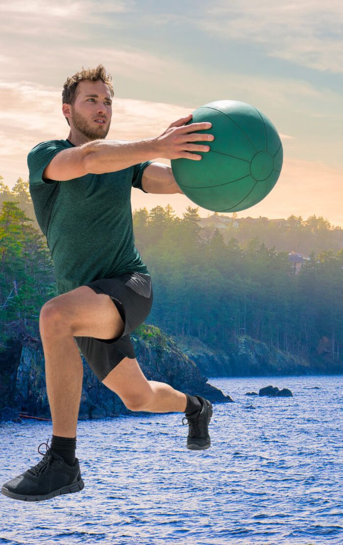 Athlete with Medicine ball with Vancouver Island shoreline in the background - Upstream Athletics