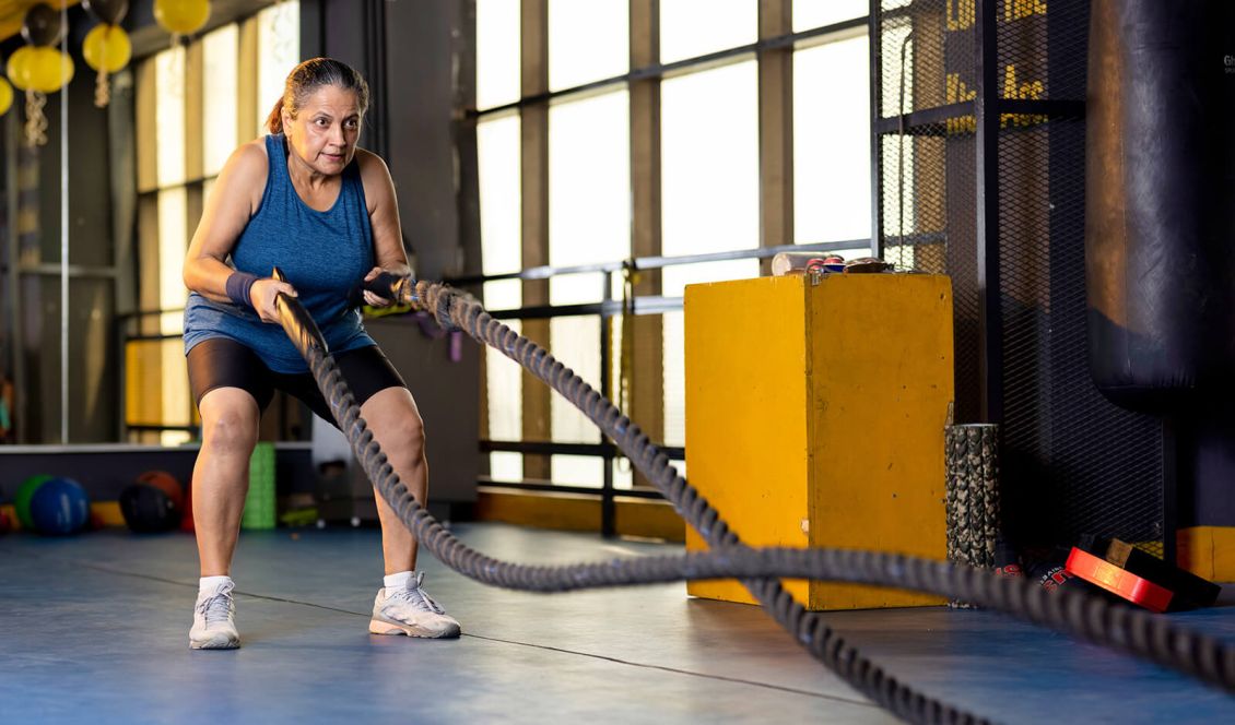 Woman working out with rope at gym Upstream Athletics